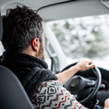 Homme conduisant une voiture en hiver